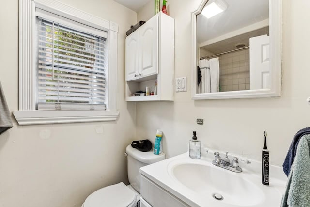 bathroom featuring walk in shower, vanity, and toilet