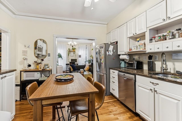 kitchen featuring ornamental molding, appliances with stainless steel finishes, sink, light hardwood / wood-style floors, and white cabinets