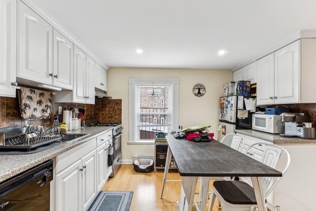 kitchen featuring light wood-type flooring, backsplash, white cabinets, a baseboard radiator, and white appliances