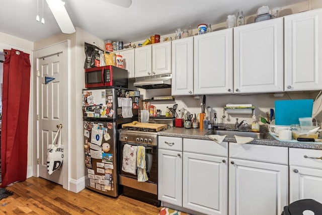 kitchen with stainless steel appliances, white cabinetry, sink, and light hardwood / wood-style flooring