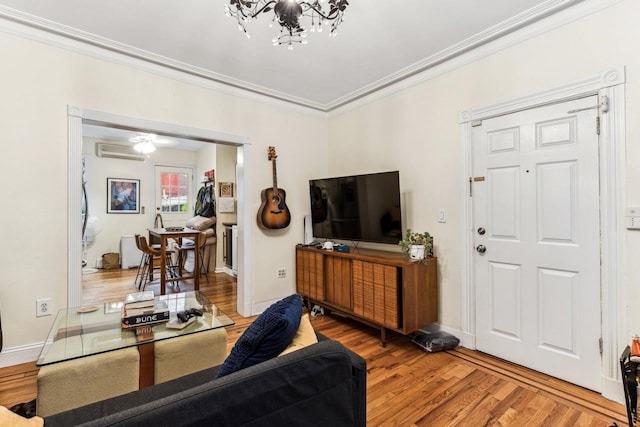 living room with wood-type flooring, a chandelier, an AC wall unit, and crown molding