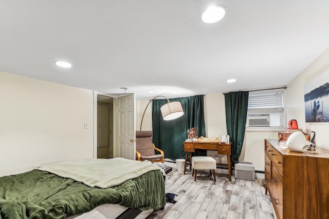 bedroom with cooling unit and light hardwood / wood-style flooring