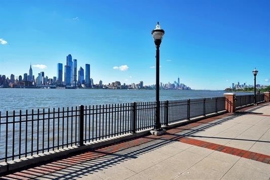 surrounding community with fence, a city view, and a water view