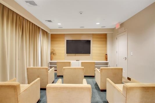 cinema featuring recessed lighting, dark colored carpet, and visible vents