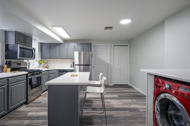 1406 8th St Unit 9, North Bergen, NJ 07047 - kitchen with washer / clothes dryer, appliances with stainless steel finishes, gray cabinetry, a sink, and a kitchen island