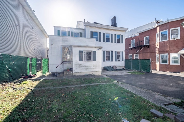 rear view of house featuring a lawn