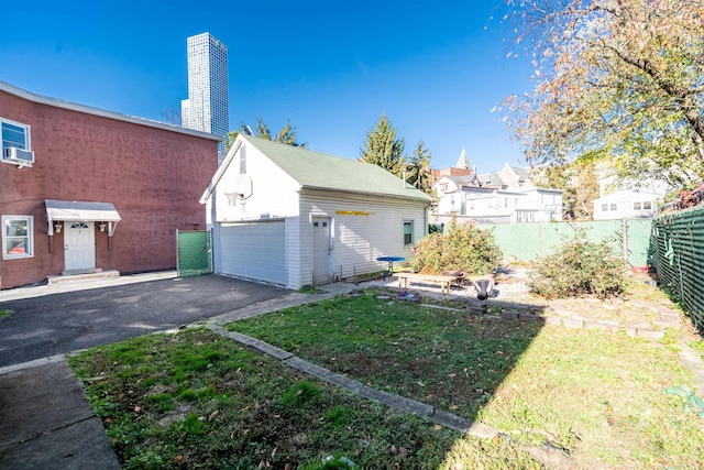 view of property exterior featuring a yard, a garage, cooling unit, and an outdoor structure