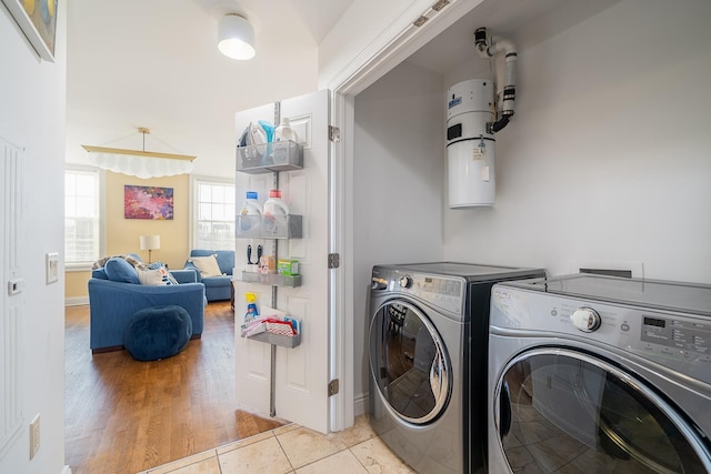 laundry area featuring separate washer and dryer, laundry area, and light tile patterned flooring