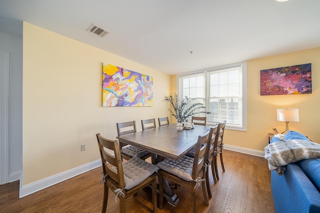 dining room with wood finished floors, baseboards, and visible vents