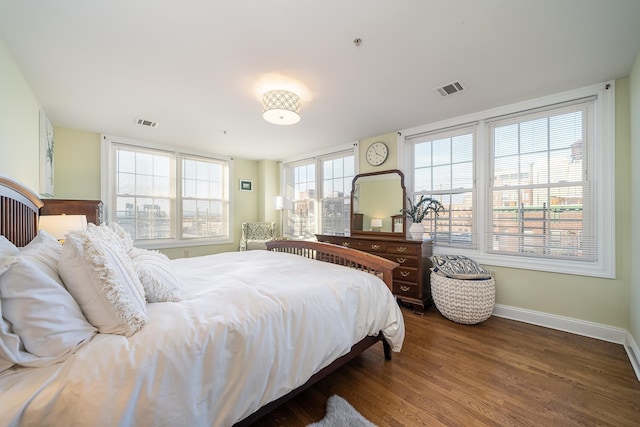 bedroom featuring dark wood-type flooring, visible vents, and baseboards