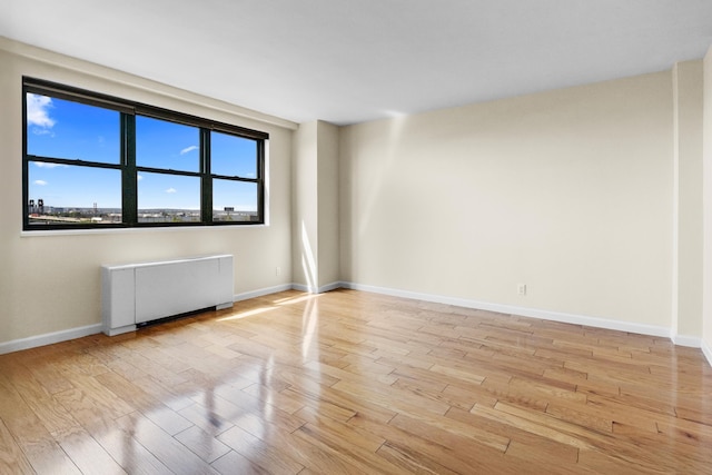 1225 Kennedy Blvd Unit 7C, Bayonne, NJ 07002 - unfurnished room with radiator, light wood-style flooring, and baseboards