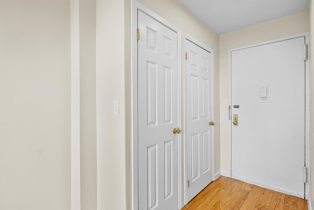 entryway with light wood-style floors and baseboards