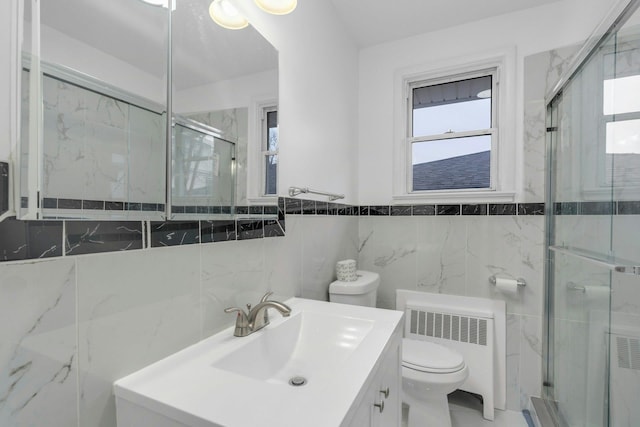 bathroom with vanity, an enclosed shower, radiator heating unit, and toilet