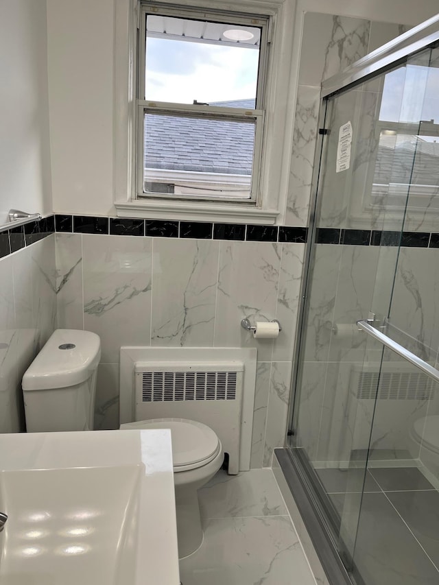 bathroom with radiator heating unit, a shower with door, and toilet