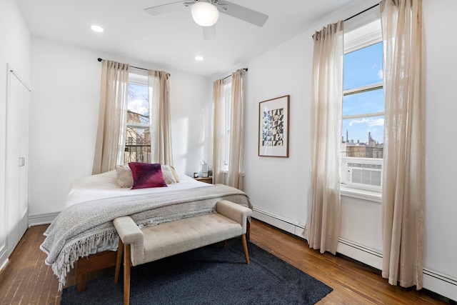 bedroom with recessed lighting, ceiling fan, baseboard heating, and wood finished floors