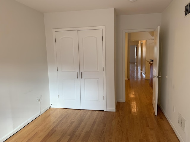 612 Palisade Ave, Jersey City, NJ 07307 - unfurnished bedroom featuring visible vents, a closet, baseboards, and wood finished floors