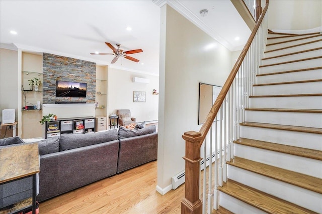 living room with built in features, hardwood / wood-style flooring, ceiling fan, and ornamental molding