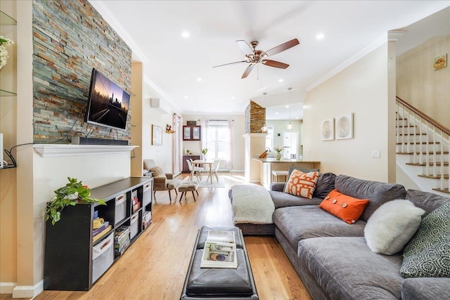 living room with light wood-type flooring, ceiling fan, and ornamental molding