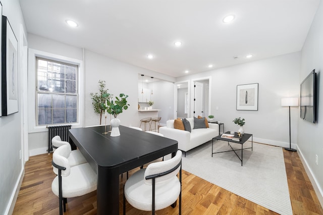 dining space featuring radiator and hardwood / wood-style floors