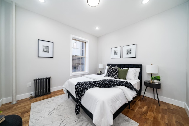 bedroom featuring wood-type flooring and radiator heating unit