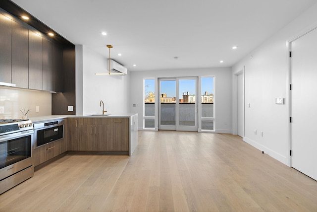 kitchen featuring light wood-style floors, modern cabinets, a sink, and stainless steel range with electric cooktop