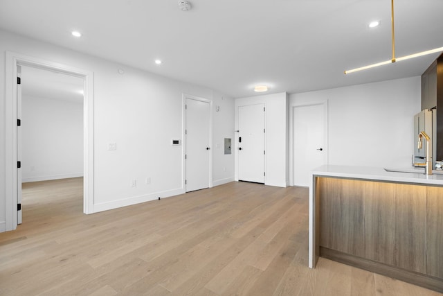 kitchen featuring recessed lighting, a sink, light wood-style floors, freestanding refrigerator, and modern cabinets