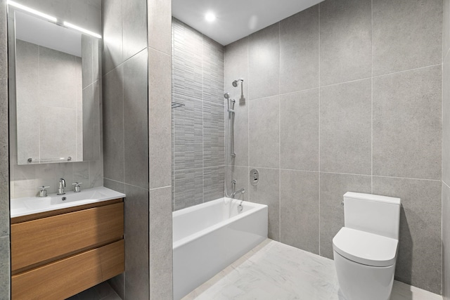 full bath featuring  shower combination, vanity, toilet, and tile walls