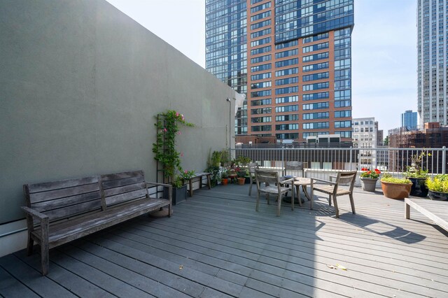 140 Bay St Unit 6E, Jersey City, NJ 07302 - wooden terrace with outdoor dining area and a city view