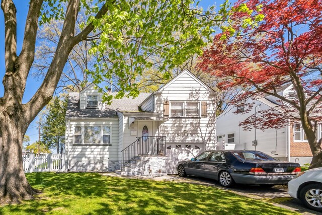 131 Iozia Ter, Elmwood Park, NJ 07407 - view of front of home featuring a front lawn, fence, a shingled roof, and a garage