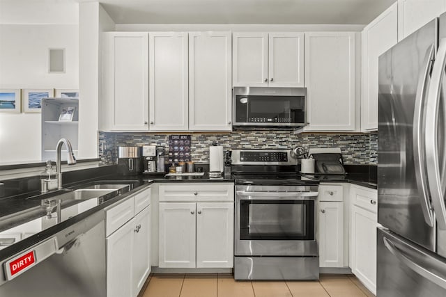 24 Ave At Port Imperial Unit 328, West New York, NJ 07093 - kitchen featuring appliances with stainless steel finishes, white cabinetry, light tile patterned floors, and backsplash