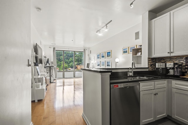 24 Ave At Port Imperial Unit 328, West New York, NJ 07093 - kitchen featuring dishwasher, dark countertops, rail lighting, a peninsula, and light wood-style flooring