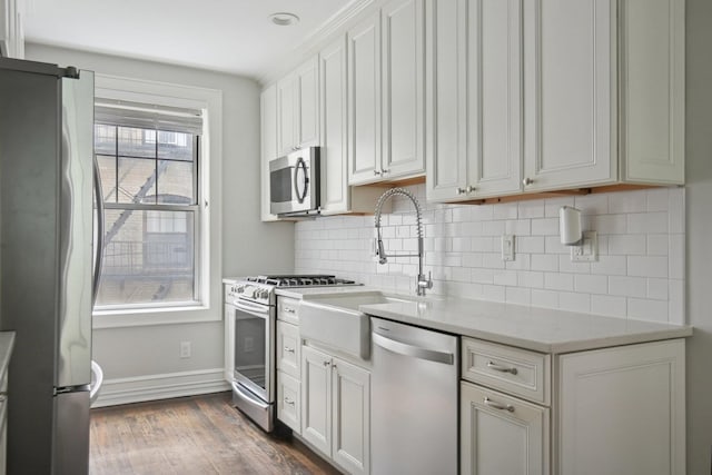 1000 Hudson St Unit 209, Hoboken, NJ 07030 - kitchen featuring appliances with stainless steel finishes, dark wood-style floors, decorative backsplash, and white cabinets