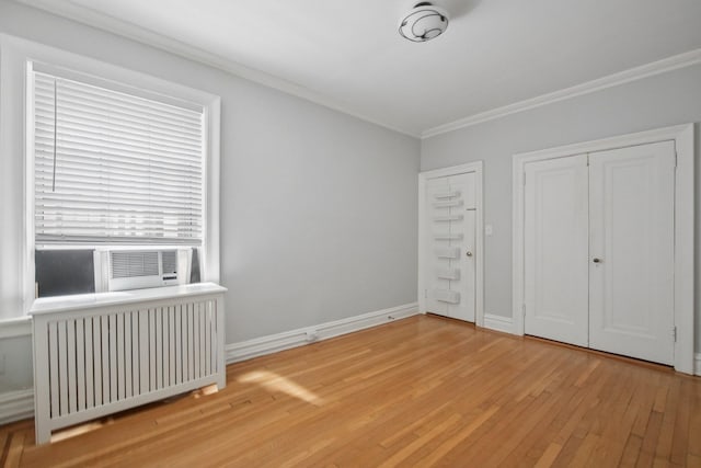 1000 Hudson St Unit 209, Hoboken, NJ 07030 - unfurnished bedroom featuring radiator, ornamental molding, wood-type flooring, and cooling unit