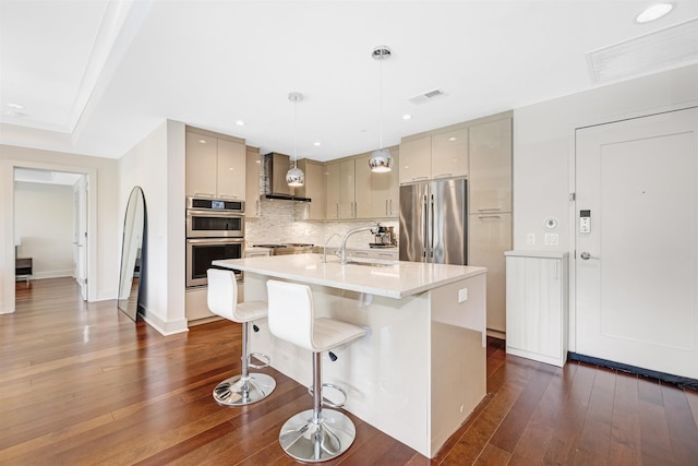150 Henley Pl Unit 202, Weehawken, NJ 07086 - kitchen featuring wall chimney exhaust hood, appliances with stainless steel finishes, dark wood finished floors, a breakfast bar, and light countertops