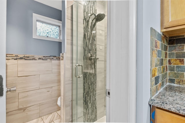 bathroom with a stall shower, vanity, and toilet