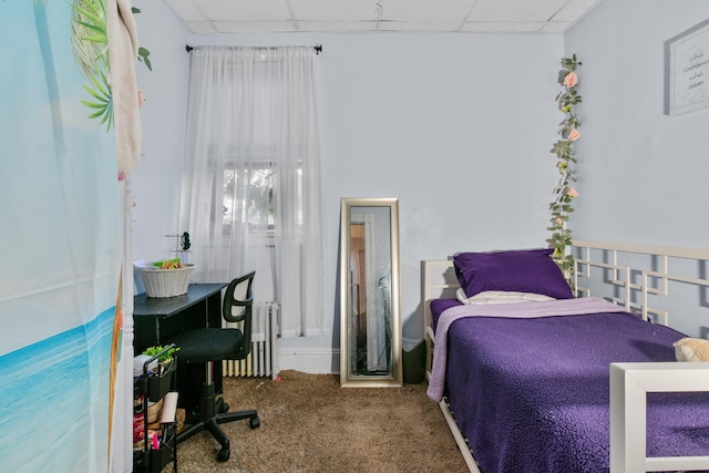 bedroom featuring radiator, carpet flooring, and a drop ceiling