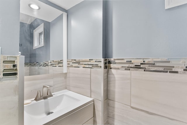 bathroom featuring vanity and tile walls