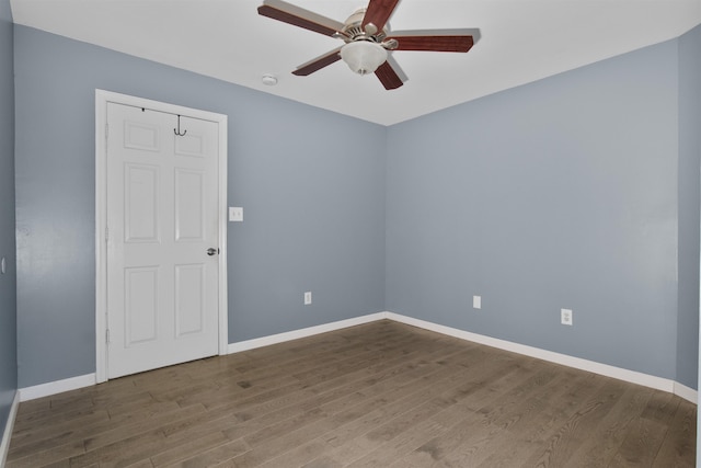 empty room with wood finished floors, baseboards, and ceiling fan