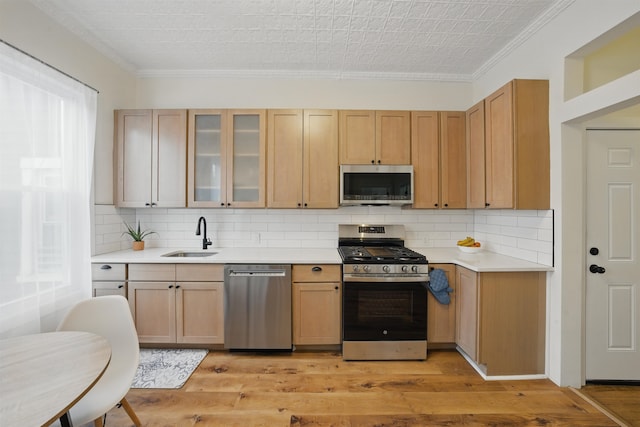 3809 Kennedy Blvd, Union City, NJ 07087 - kitchen featuring stainless steel appliances, a sink, ornamental molding, light countertops, and light wood-style floors