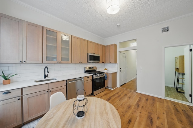 3809 Kennedy Blvd, Union City, NJ 07087 - kitchen with appliances with stainless steel finishes, a sink, backsplash, light countertops, and ornamental molding