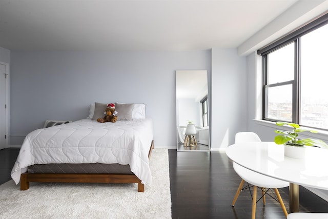 bedroom with wood finished floors and baseboards