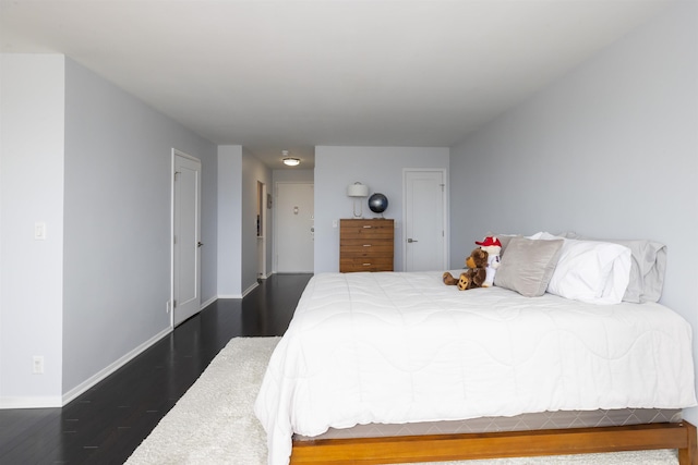 bedroom featuring wood finished floors and baseboards