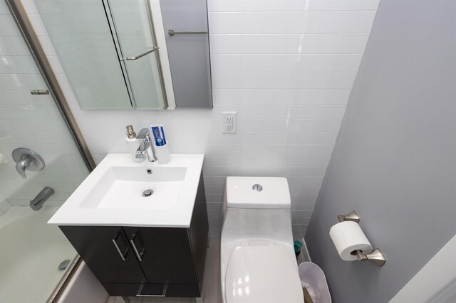 bathroom with toilet, bath / shower combo with glass door, and vanity