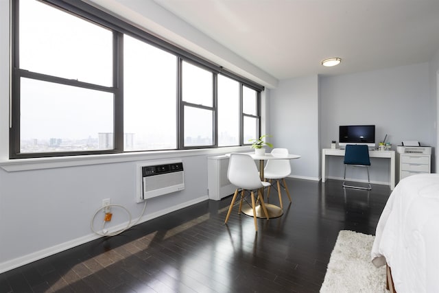 bedroom with baseboards, dark wood-type flooring, a desk, and a wall mounted air conditioner