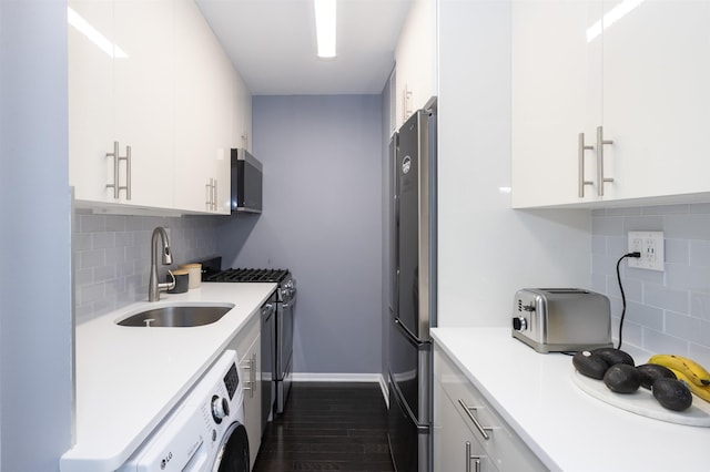 kitchen with a sink, washer / dryer, stainless steel appliances, tasteful backsplash, and white cabinetry