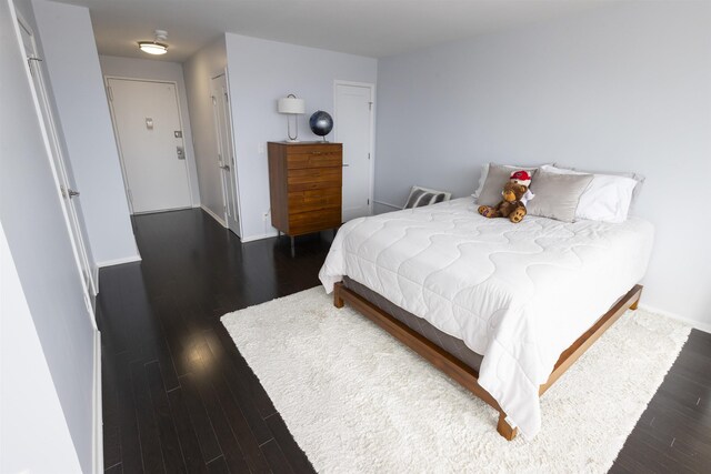 bedroom with wood finished floors and baseboards