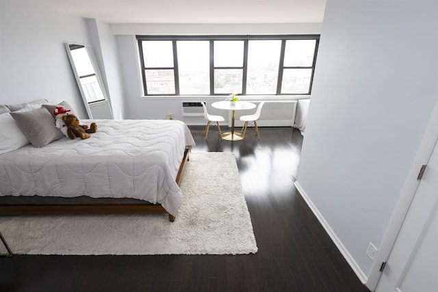 bedroom featuring multiple windows, dark wood-type flooring, and baseboards