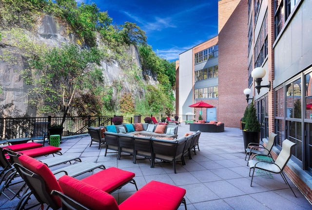 view of patio with an outdoor living space with a fire pit