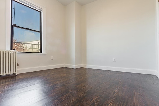 unfurnished room with dark wood-type flooring and radiator