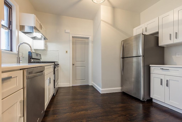 kitchen featuring white cabinetry, sink, dark wood-type flooring, decorative backsplash, and appliances with stainless steel finishes